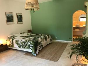 a bedroom with a bed and a green wall at Les Bosquets in Lorgues