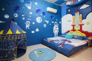 un dormitorio infantil con una pared azul con astronauta y planetas en Cape 42 Hotel Il, en Hengchun