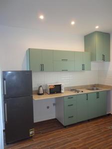 a kitchen with green cabinets and a black refrigerator at La Casa Beach in Hurghada