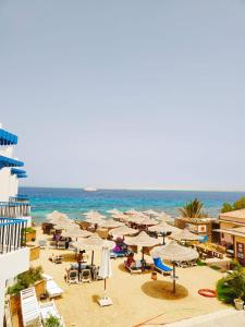 a beach with umbrellas and chairs and the ocean at La Casa Beach in Hurghada