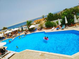 a large swimming pool with people in the water at La Casa Beach in Hurghada