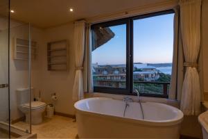 Un baño con bañera y una gran ventana. en Dolphin Sunrise, en Jeffreys Bay 59 fotos más