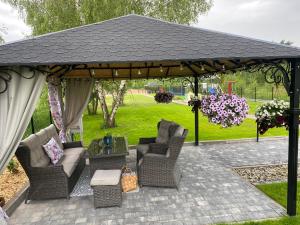 a gazebo with couches and chairs on a patio at Stara Kuźnia in Łuków