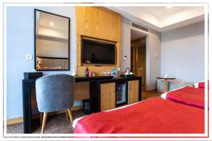 una camera d'albergo con scrivania e TV di Premium Hotel Ganja a Ganja