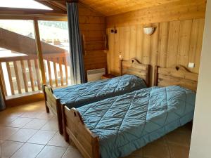 een slaapkamer met een bed in een blokhut bij Le Lessy M4 in Le Grand-Bornand
