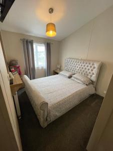 a bedroom with a large bed and a window at Luxury Lodge in Heysham