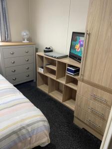 a bedroom with a desk with a laptop on it at Luxury Lodge in Heysham