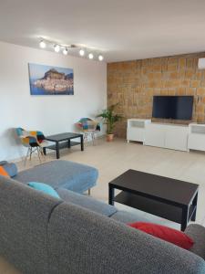 a living room with a couch and a tv at Kalura Sea House in Cefalù