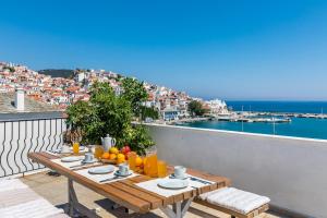a table on a balcony with a view of the ocean at Regina Hotel in Skopelos Town