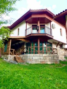 uma casa grande com uma varanda no topo de um quintal em Pamporovo Villa em Pamporovo