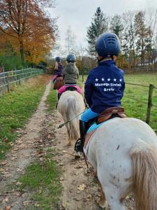um grupo de pessoas andando a cavalo por uma estrada de terra em Vakantiehuis Mastdreef em Breda