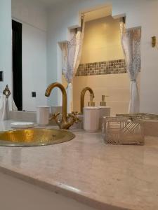 um balcão de casa de banho com dois lavatórios e duas torneiras em Appartement aux portes de la palmeraie em Marraquexe