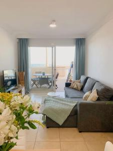 a living room with a couch and a table at Apartamento con vistas al mar el Porís in Poris de Abona