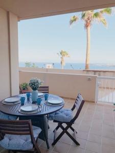 un tavolo e sedie su un balcone con vista sull'oceano di Apartamento con vistas al mar el Porís a Poris de Abona