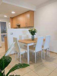 uma cozinha com uma mesa e cadeiras brancas e uma mesa e uma mesa e cadeiras em Apartamento con vistas al mar el Porís em Poris de Abona