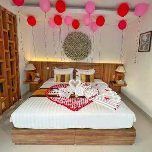 a bedroom with a bed with red and pink balloons at The Sakaye Villas & Spa in Legian