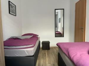 a bedroom with two beds and a mirror at Appartements Nordhausen in Nordhausen