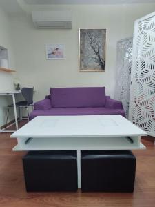 uma mesa branca com um sofá roxo num quarto em Madrid AlcoTour Apto trabajo y relax em Alcobendas