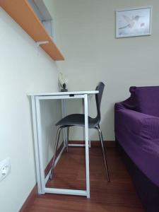 a chair sitting under a table in a room at Madrid AlcoTour Apto trabajo y relax in Alcobendas