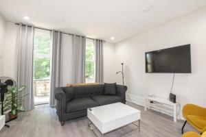 a living room with a couch and a tv at Large Bright Apt. Newly Renovated. Great Rates! in St. Catharines