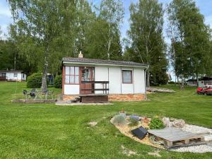 a small house in a yard with a green lawn at Retro chatky Hůrka Lipno in Horní Planá