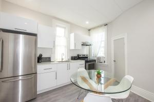 a kitchen with a glass table and a stainless steel refrigerator at Large Bright Apt. Newly Renovated. Great Rates! in St. Catharines