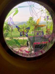 a stained glass window with a view of a field at Happy Hobbit ,2 room jakuzi, Lake view, fireplace in Sapanca 1 in Sapanca