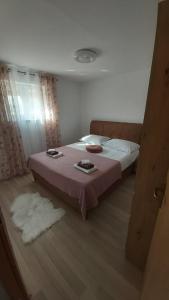 - une chambre avec un grand lit et une couverture rose dans l'établissement Luka, à Galovac
