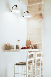 a kitchen with two white stools at a counter at Filia Solis - Old Town SUITEs & SPA in Brindisi