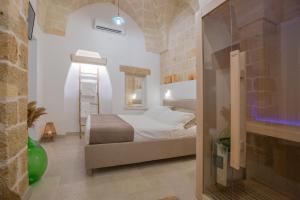 sypialnia z łóżkiem i ceglaną ścianą w obiekcie Filia Solis - Old Town SUITEs & SPA w mieście Brindisi