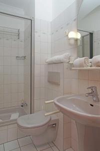 een witte badkamer met een wastafel en een toilet bij Fischerhus _ Wohnung 2 in Cuxhaven