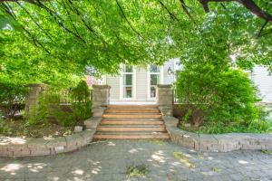 a stairway leading to a white house with trees at Large Bright Apt. Newly Renovated. Great Rates! in St. Catharines