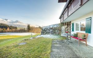a house with a red bench and a stone wall at Ferienwohnungen Alpentraum - Traumblick in Bolsterlang +5 photos