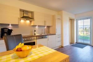 a kitchen with a table with a bowl of fruit on it at Ferienwohnungen Alpentraum - Traumblick in Bolsterlang