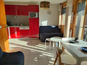 Il comprend une cuisine et un salon avec des placards rouges. dans l'établissement Studio & piscine intérieure, vue Mont D'Arbois, à Saint-Gervais-les-Bains