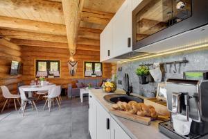 a kitchen with wooden walls and a dining room at NOVAK CHALET domki z balią Krynica Zdrój in Krynica Zdrój