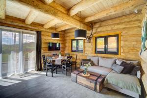 a living room with a couch and a table at NOVAK CHALET domki z balią Krynica Zdrój in Krynica Zdrój +60 photos