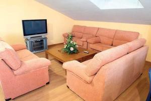 Una sala de estar con un sofá y dos sillas y un televisor. en Ele Mirador de Santa Ana, en Ávila