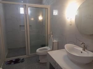a bathroom with a toilet and a sink and a shower at Villa Casa Camba, Barangay Bued in Alaminos