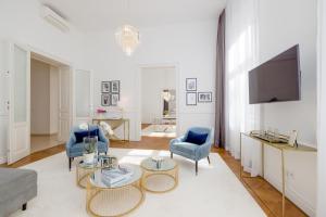a living room with two blue chairs and a tv at RAFAEL KAISER - Premium Apartments City Centre - Contactless Check-In in Vienna