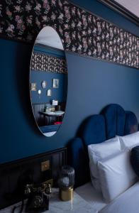 a bedroom with a blue wall with a mirror at Craves in Brussels