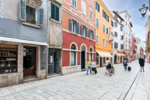 een groep mensen die door een straat met gebouwen lopen bij Adriatic Dream Rooms in Rovinj