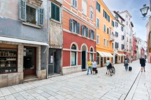 een groep mensen die door een straat met gebouwen loopt bij Adriatic Dream Rooms in Rovinj