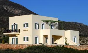 una casa blanca con una colina en el fondo en Anemoni en Diakofti