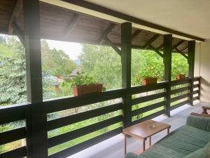 una veranda schermata con divano e tavolo di Casa Cris a Durau