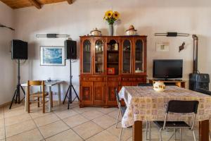 ein Wohnzimmer mit einem TV, einem Tisch und einem Schrank in der Unterkunft Villetta Patty in Scoglitti