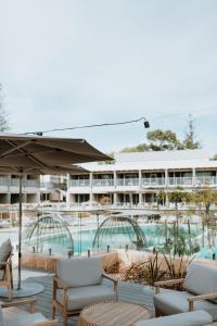 a resort with a pool and chairs and a building at Samphire Rottnest in Rottnest Island