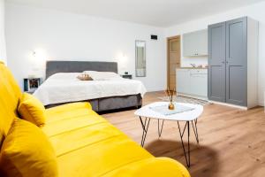 een woonkamer met een gele bank en een bed bij Adriatic Dream Rooms in Rovinj