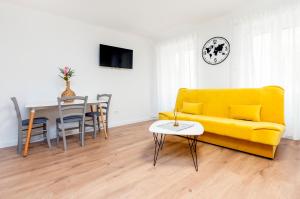 een woonkamer met een gele bank en een tafel bij Adriatic Dream Rooms in Rovinj
