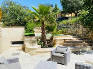 une terrasse avec des chaises, un palmier et des escaliers. dans l'établissement Camin del Bosc, à Roquefort-des-Corbières